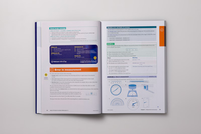 Photo of a layout design spread showing a combination of text, tables and illustrations.    
